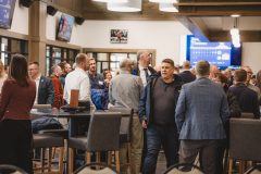 People gathering in brightly lit facility.