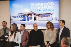 People stand behind woman speaking