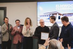 People applaud after cutting celebratory ribbon