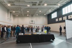 Man speaks to large crowd in a gymnasium