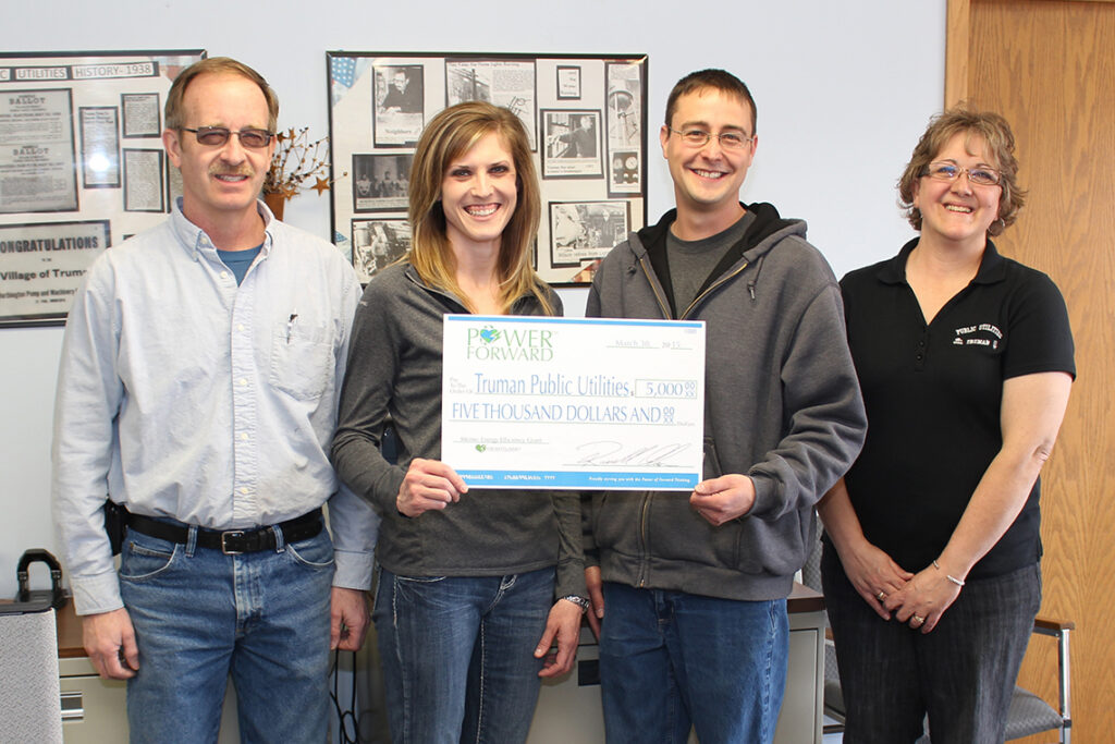 Heartland Communications Manager Ann Hyland, second from left, presents an energy efficiency grant to Truman Commission Chair Brad Nickerson, Public Utilities Foreman Justin Anderson and Public Utilities Office Manager Judi Davis.