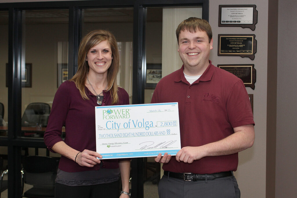 Heartland Communications Manager Ann Hyland presents an energy efficiency grant to Volga City Administrator Andrew Bremseth.