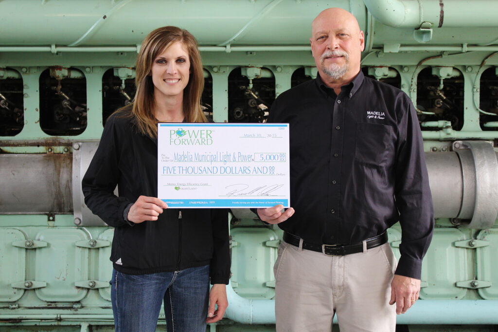 Heartland Communications Manager presents an energy efficiency grant to Madelia Municipal Light & Power General Manager Jim Maras.