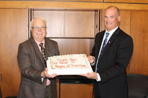 Heartland Chairman of the Board Merlin VanWalleghen, left, recognizes CEO Russell Olson for his ten years of outstanding service.