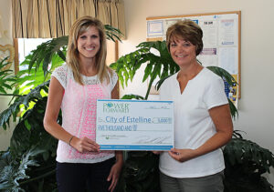 Ann Hyland presents an energy efficiency grant to Estelline Finance Officer Mary Saathoff. 