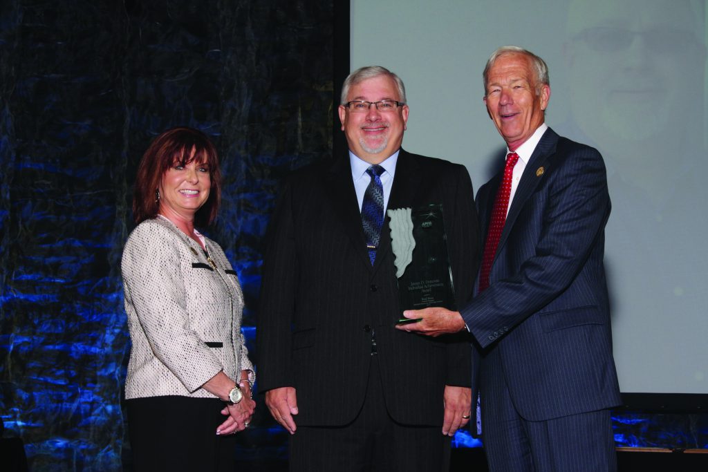 Brad Roos, center, receives the James. D. Donovan Individual Achievement Award from APPA board chair Paula DiFonzo and past chair Gary Stauffer.