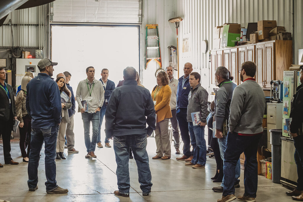 group of people inside Mustang Seeds facility