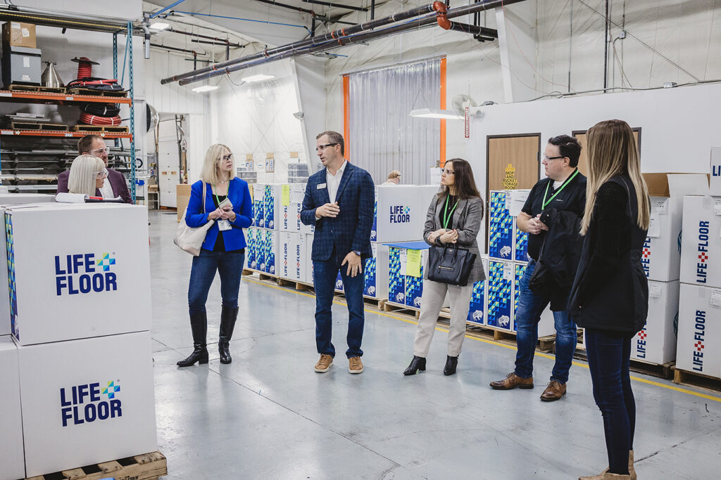 group of people standing in between Life Floor boxes