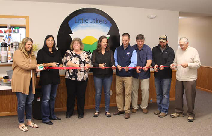 care center officials holding a ribbon for their ribbon cutting and open house