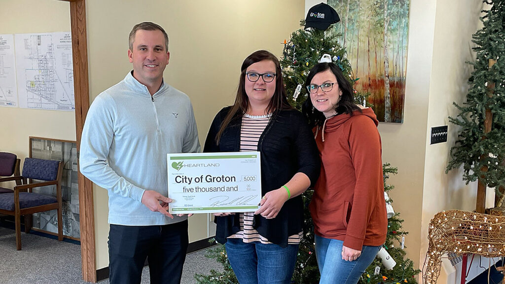 Heartland Director of Economic Development Casey Crabtree, left, presents an economic development grant to city employees Block and Abeln.