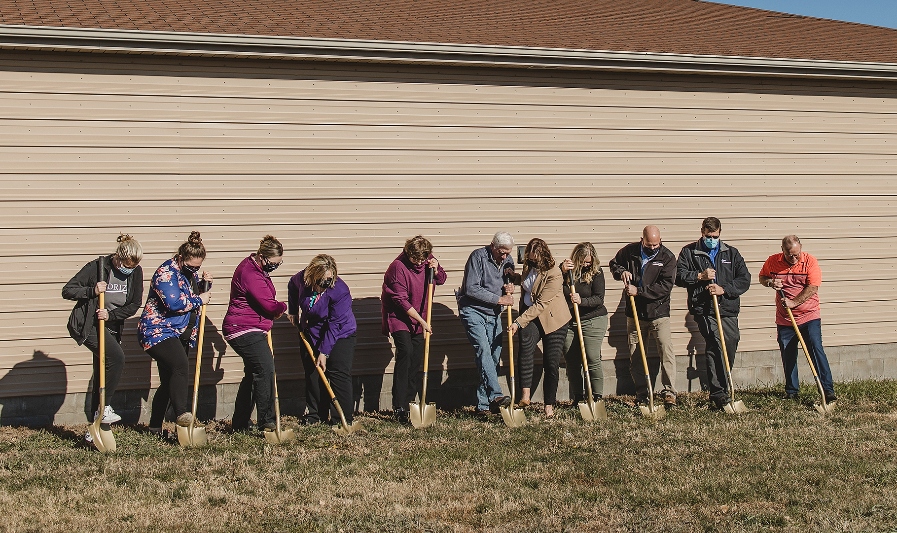 Healthcare center staff holding shovels for the clinics groundbreaking