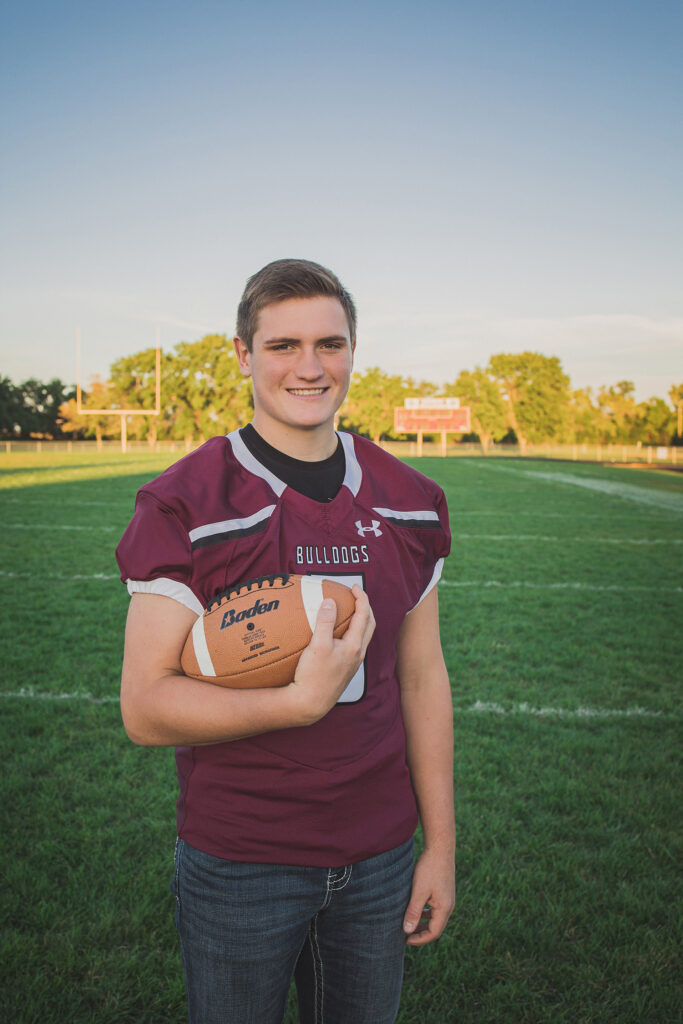 football player holding a football on the field