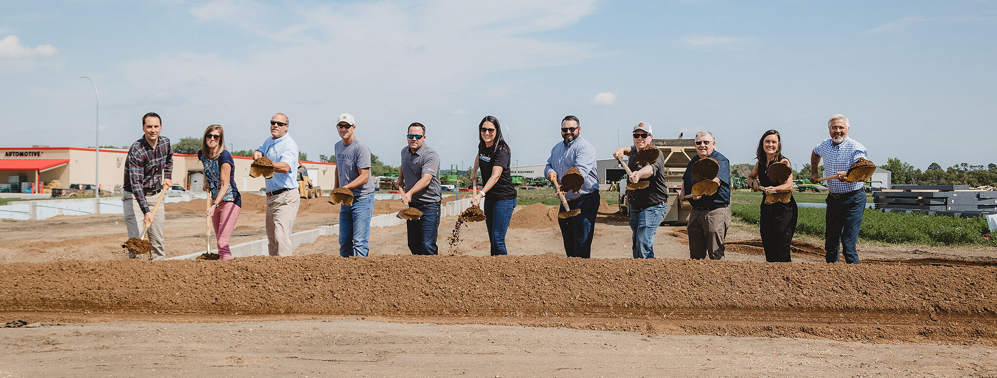 groundbreaking ceremony, people lined up with shovels doing ceremonial dirt toss