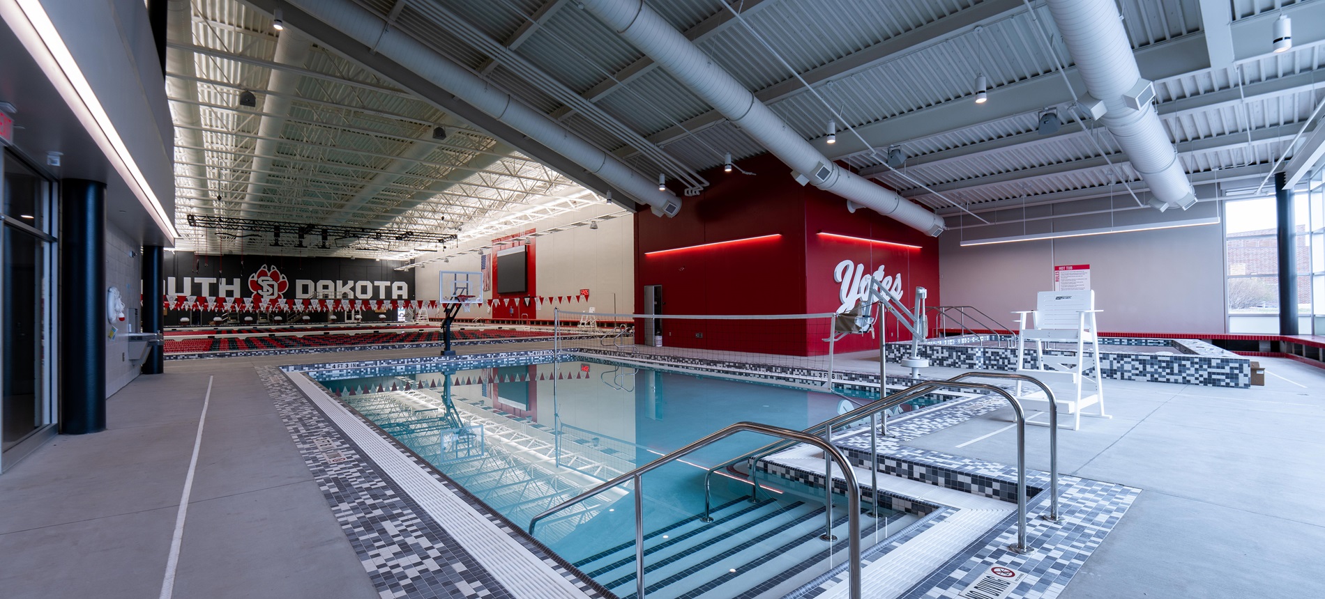 Interior of aquatic facility with leisure pool in the foreground. USD branding on the walls.