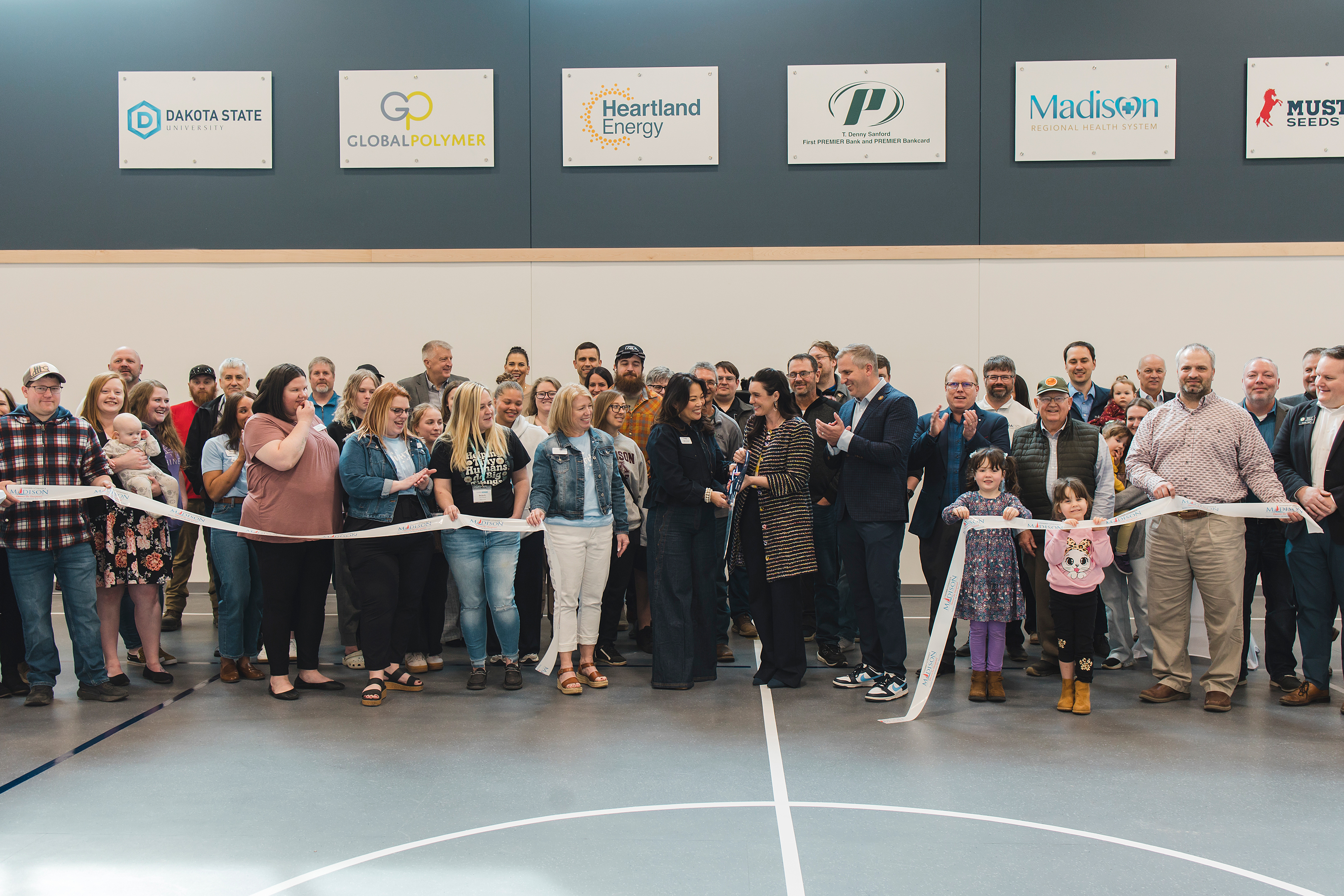 large crowd as two women cut a ceremonial ribbon